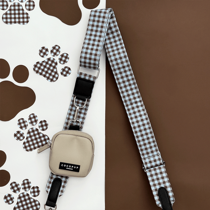 A brown and blue check print bag strap. with a beige treat pouch attached, for dog treats.