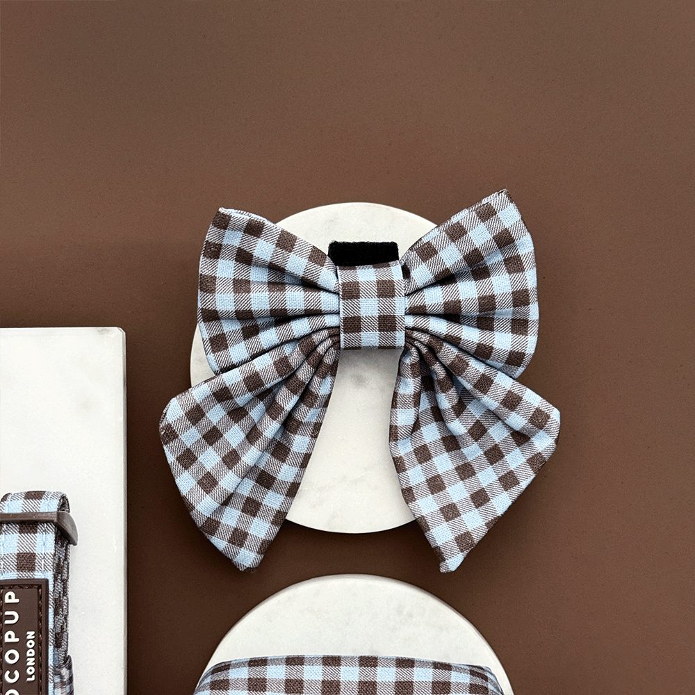A brown and blue check print sailor bow tie for dogs. With velcro fastening.