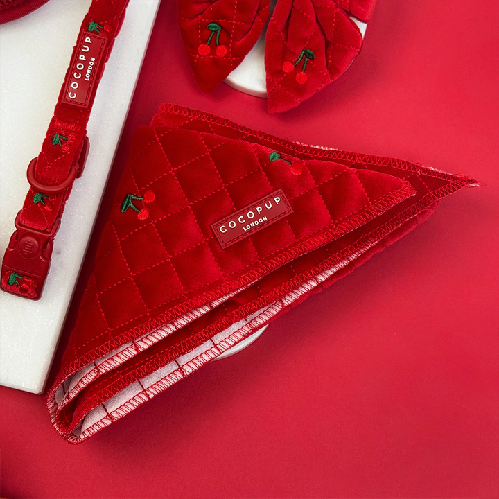 Red quilted handbag with cherry details and 'COCOPUP' branding on a red background