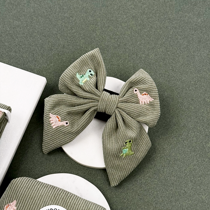 Green corduroy material Dog Sailor Bow Tie with embroidered dinosaurs. 