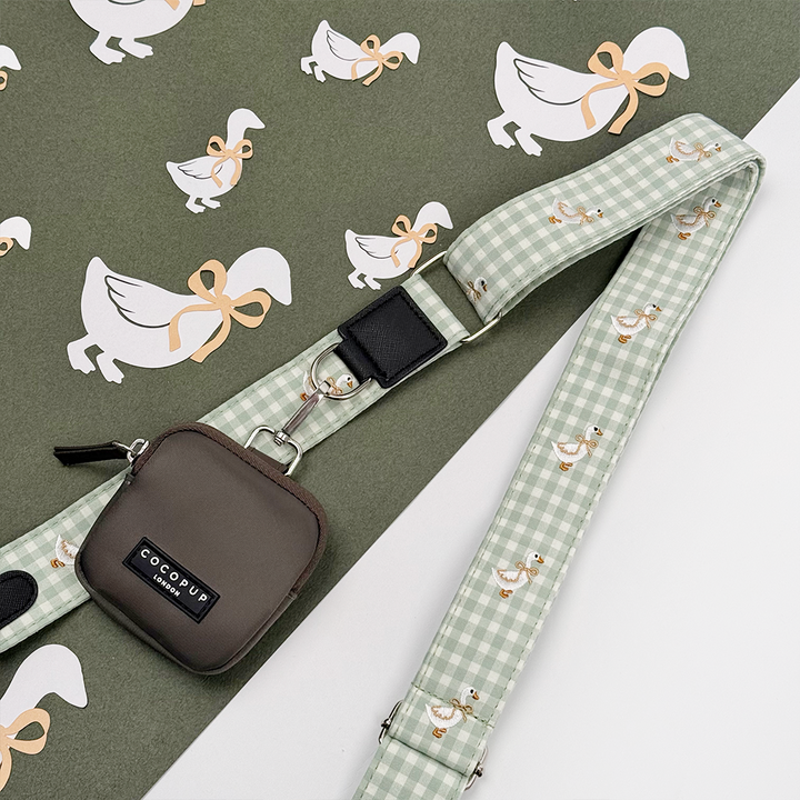 Green and white check print bag strap with embroidered geese design.